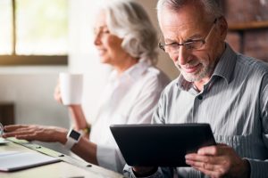older man and woman using tablet