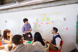 A businessman is giving a presentation in a modern co-working space.