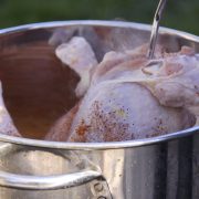 Turkey being placed into a deep fryer