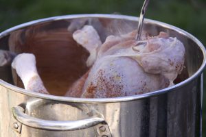 Turkey being placed into a deep fryer