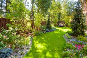 Landscape design with plants and flowers at residential house. Scenic view of nice landscaped garden in backyard.