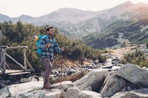 Backpacker crossing a stream in the mountains