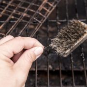 Person's hand showing loose bristle from wire grill cleaning brush. Dangerous when it sticks to meat or other food and a person accidentally swallows it. Digestion damage, life threatening situation.