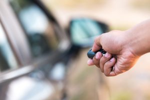 Image of someone using a car remote / keyless entry to unlock a car