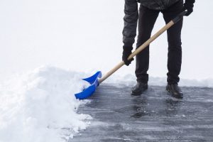 An image of someone shoveling snow, part of snow and ice removal