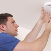 Man Installing Smoke Or Carbon Monoxide Detector