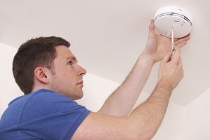 Man Installing Smoke Or Carbon Monoxide Detector